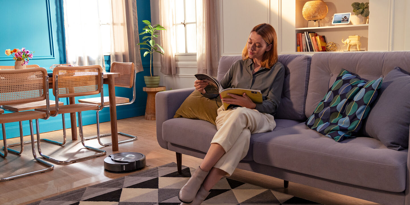 Vrouw leest terwijl de roomba combo schoonmaakt